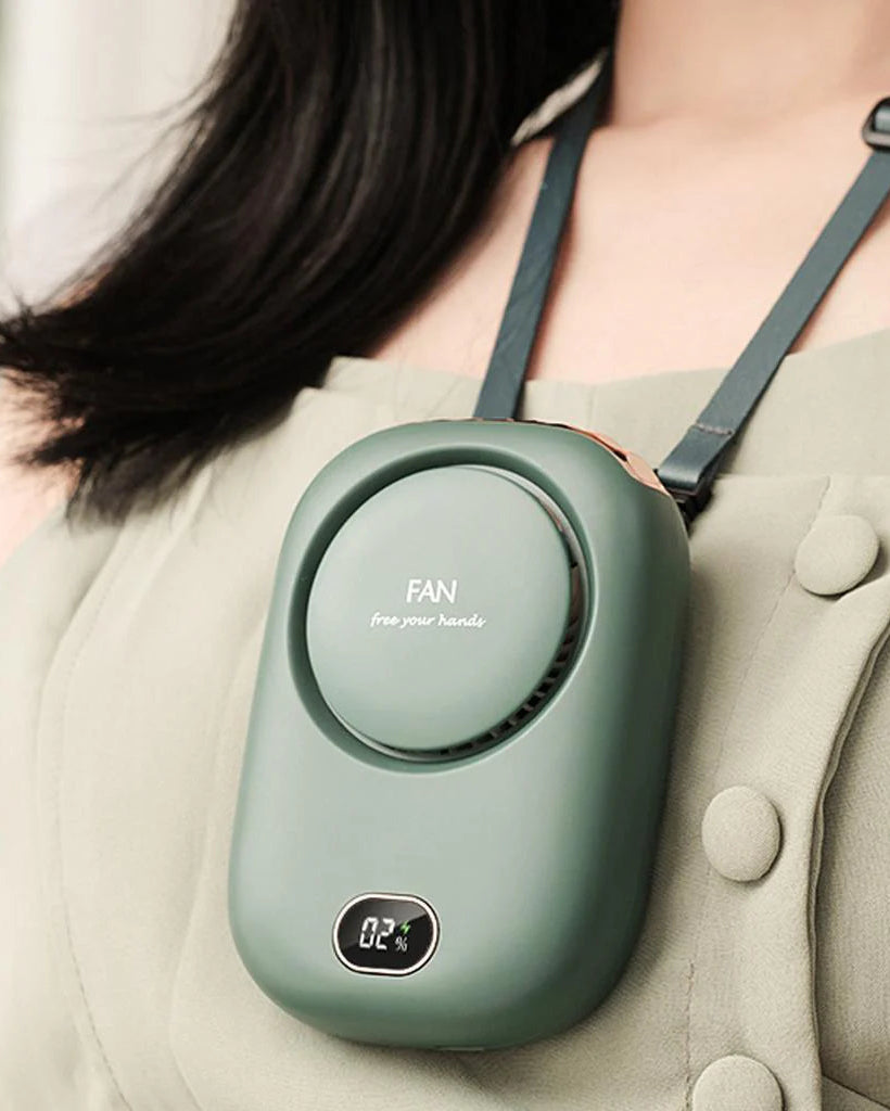 Fern green CoolBreeze bladeless neck fan hanging from its adjustable lanyard against a beige button-front dress, battery display lit